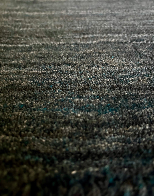 Shadow Smoke is a hand-tufted rug from a blend of wool and silky viscose with a smooth pile and a 12-14mm pile height. Colour black with light grey and silver accents. Sizes 160 X 230, 200 X 290 and 240 X 340. Close Angle.