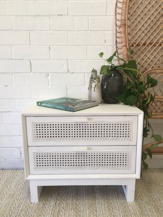 The Shasta 2 Drawer White Bedside offers a modern coastal aesthetic. Crafted from white cedar and rattan and featuring two drawers, on wood runners. Colour white. Measures 600 wide X 350 depth X 500 height. Front Styled.