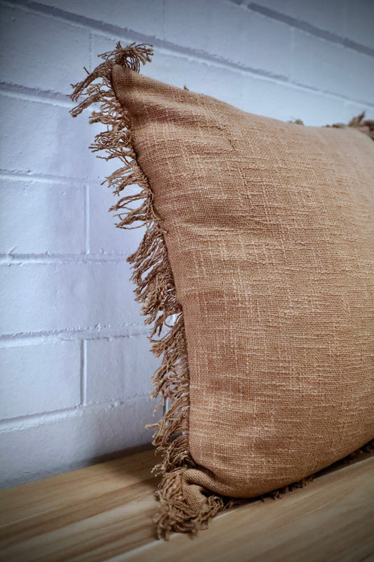 The Sun Baked, orange, throw cushion is made by skilled artisan weavers in India. Crafted from cotton slub, it features a luxurious textured feel. Boasts tasseled edges. Colour burnt orange. Sizes, 50 X 50 and 60 X 60. Angle.