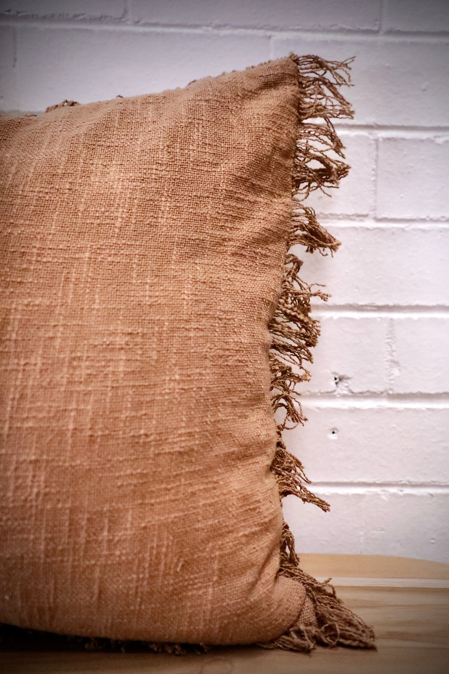 The Sun Baked, orange, throw cushion is made by skilled artisan weavers in India. Crafted from cotton slub, it features a luxurious textured feel. Boasts tasseled edges. Colour burnt orange. Sizes, 50 X 50 and 60 X 60. Side.