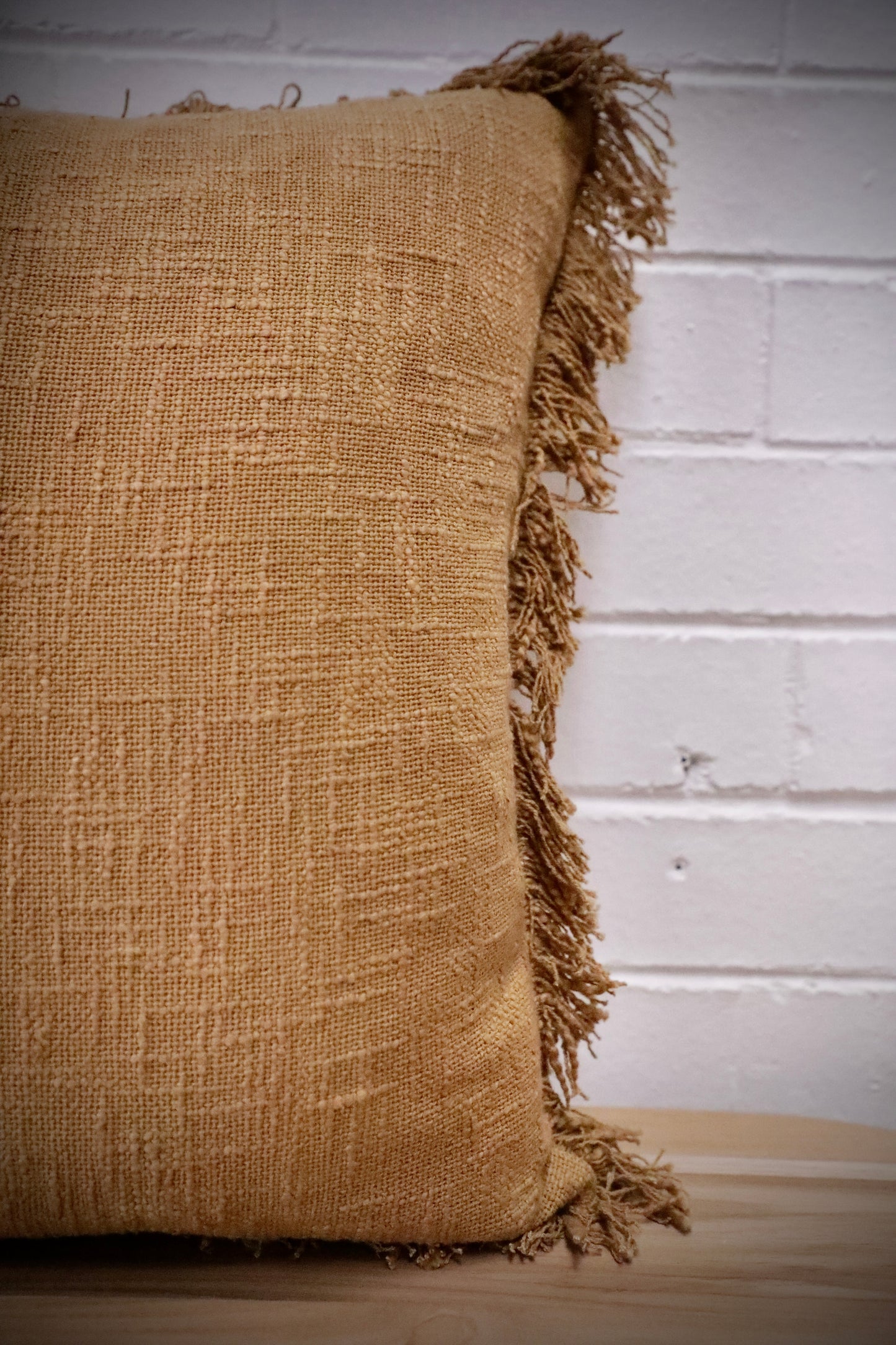 The Sun Baked, yellow, throw cushion is made by skilled artisan weavers in India. Crafted from cotton slub, it features a luxurious textured feel. Boasts tasseled edges. Colour burnt yellow. Sizes, 50 X 50 and 60 X 60. Side.