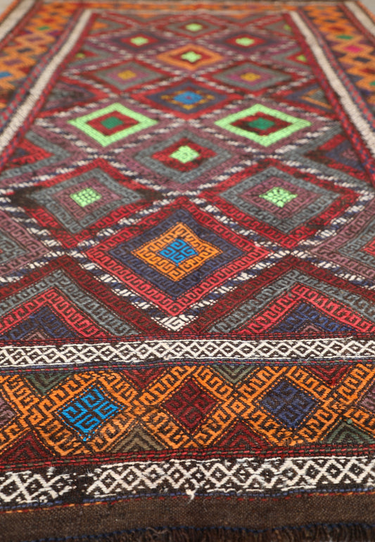 The Afghan Hand Woven Wool Suzani Kilim - 155 X 251. Features traditional geometric designs, hand crafted by Afghan artisan weavers. Colours, dark browns, oranges, blues and creams. Measures 155 wide X 251 long. Angle.