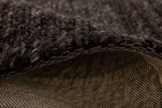 Svend Charcoal is a contemporary hand woven braided pile wool rug. Colour Charcoal/black. Sizes 155 X 225, 200 X 290, 240 X 320 and 300 X 400. Side.