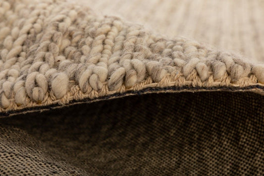 Svend Greyology is a contemporary hand woven braided pile wool rug. Colour Light Grey. Sizes 155 X 225, 200 X 290 and 300 X 400. Side.