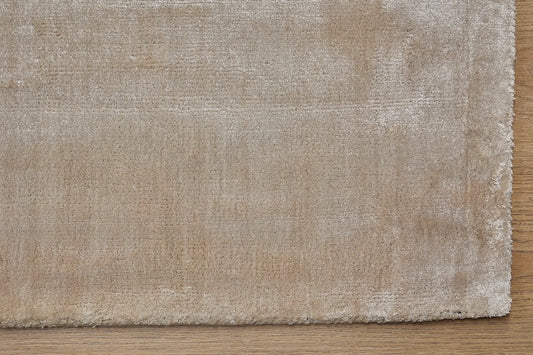 Tempo Beige is a hand-loomed and hand tufted rug. Crafted with bamboo silk, it offers medium texture and has a pile height of 10-12mm. Colour beige. Sizes 160 X 230, 200 X 290 and 240 X 340. Corner.