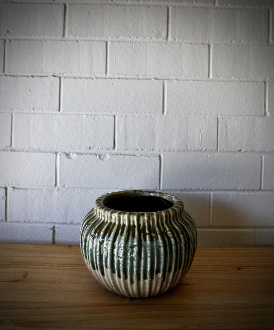 The Varuna Ceramic Pot - Small, features a textured ribbed outer shell. Great for small plants. Colour, Olive and Teal. Size 20 Diameter X 14 Height. Plain.