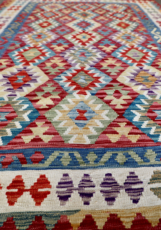 The Afghan Hand Woven Khyber Kilim - 175 X 240. Crafted using traditional vegetable dyed wool, and featuring traditional geometric designs. Colours, red, blue, yellow, teal, beige. Size 175 X 240. Angle.