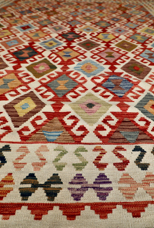 The Afghan Hand Woven Khyber Kilim - 278 X 376. Crafted using traditional vegetable dyed wool, and featuring traditional geometric designs. Colours, cream, blues, reds, oranges, yellow and teals. Size 278 X 376. Angle.