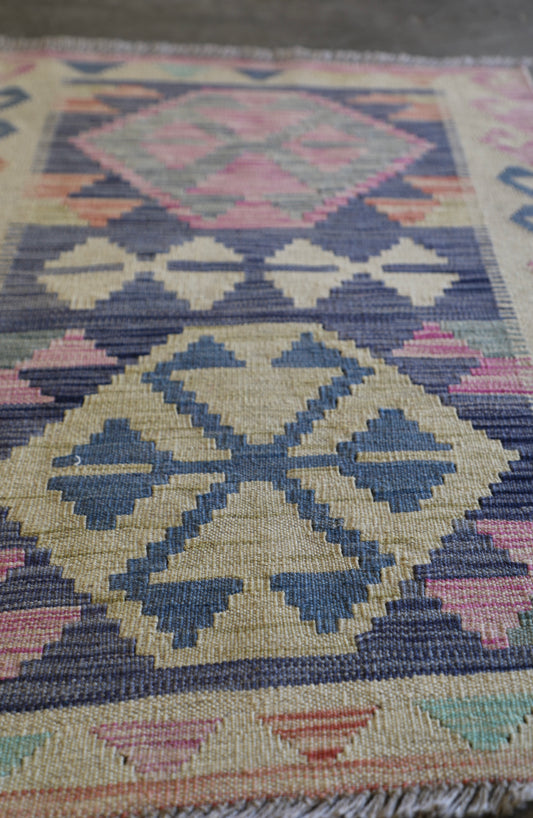 The Afghan Hand Woven Khyber Kilim 63 X 89. Crafted using traditional vegetable dyed wool, and featuring traditional geometric designs. Colours, beiges, light greys, blues. Size 63 X 89. Angle.