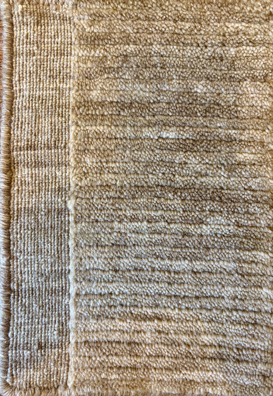 Close-up of the Yarra Camel piled wool rug showing the low channeled pile texture and flat woven border edge. Available in 4 sized. Close view.