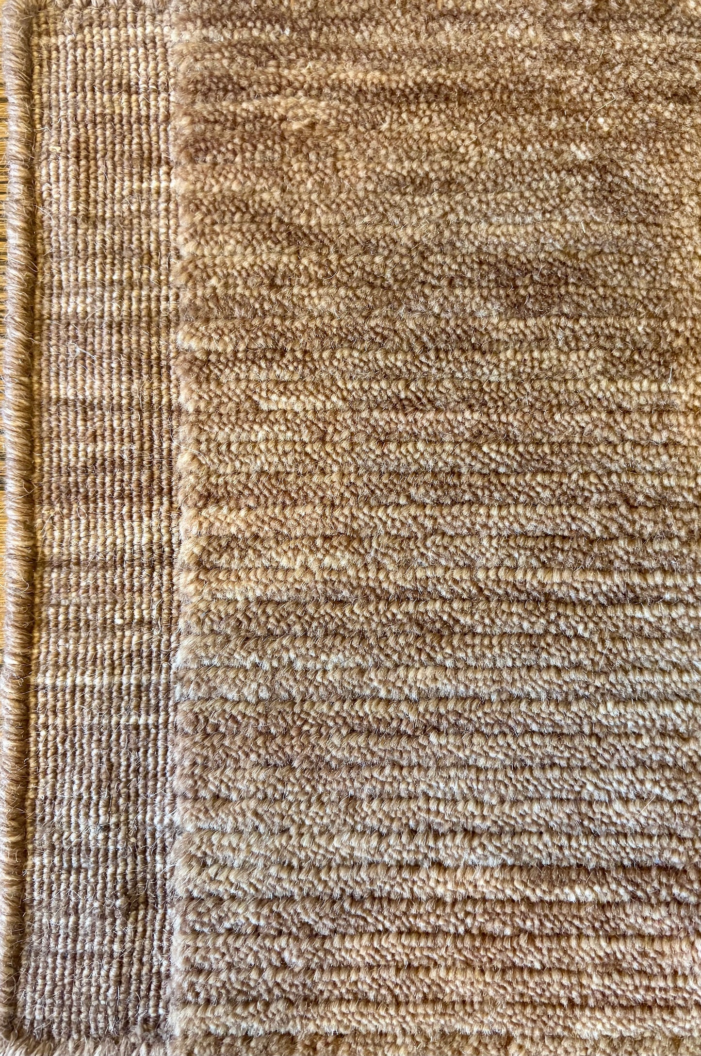 Close-up of the Yarra Rust piled wool rug showing the low channeled pile texture and flat woven border edge. Available in 4 sized. Close view.