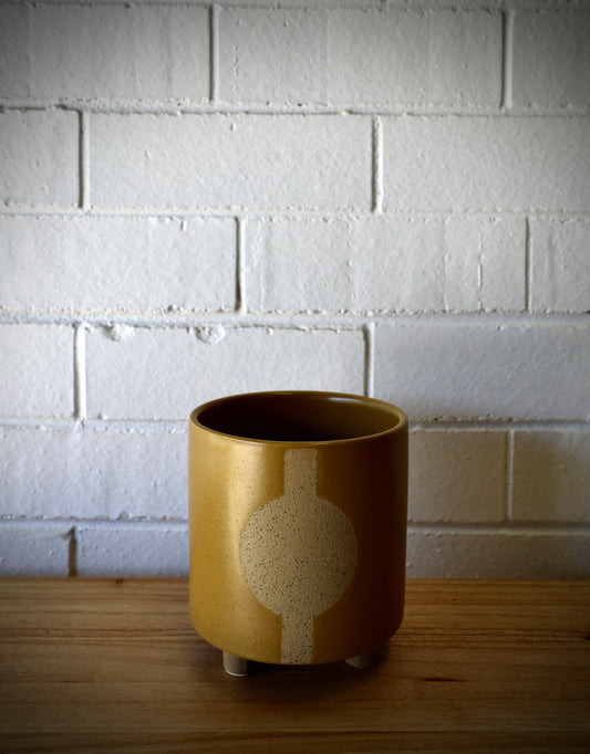The Zod Ceramic Pot - Small, is a modern simplistic designed planter pot. Its smooth texture and round feet add a modern feel. Colour Orange. Size 14 diameter x 15.5 height. Plain.