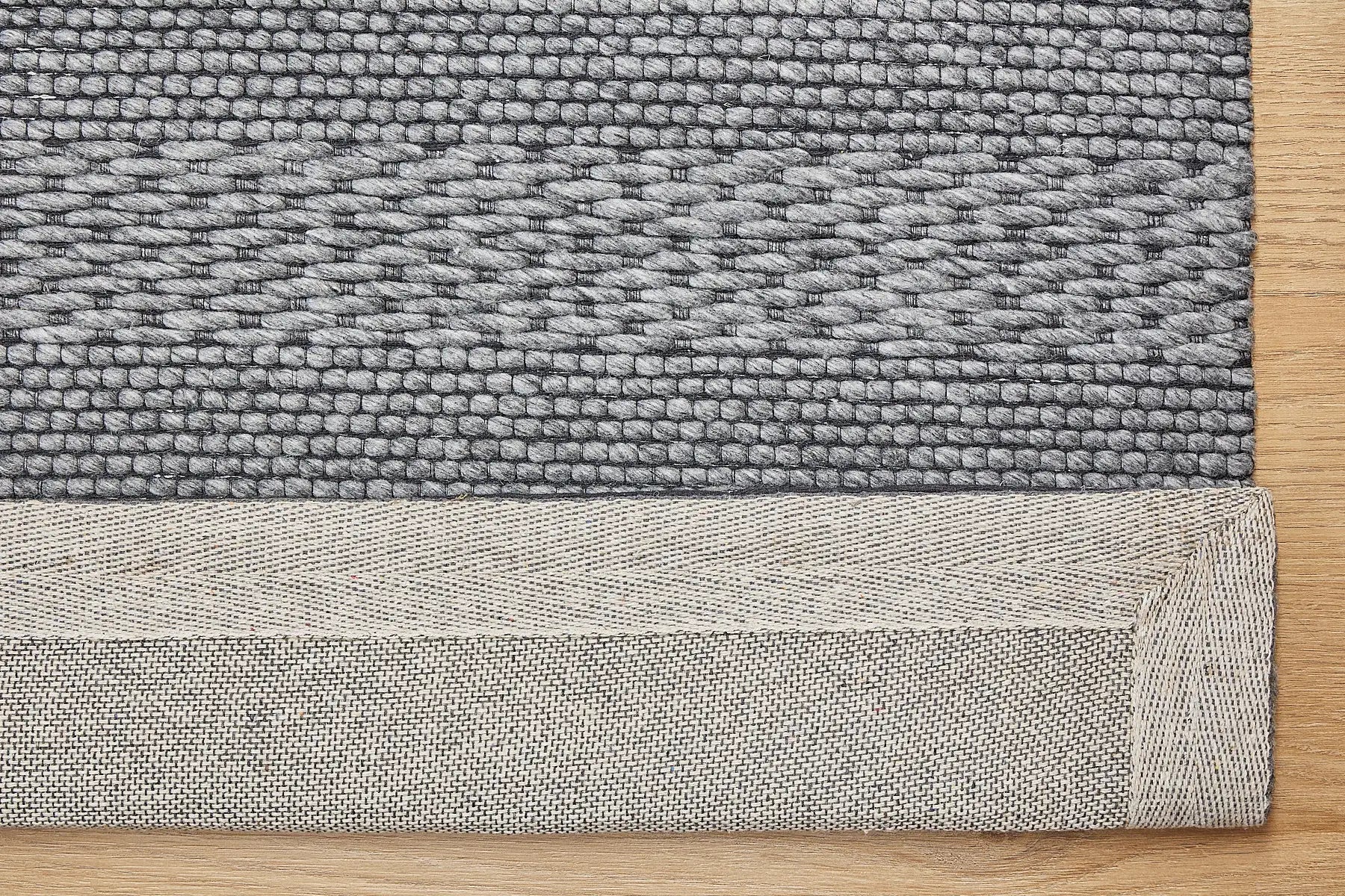 Albi Smoke is a Dark Grey and Black, PET Yarn (recycled Plastic) Hand woven rug. Sizes 160 X 230, 200 X 290 and 240 x 340. Fold.