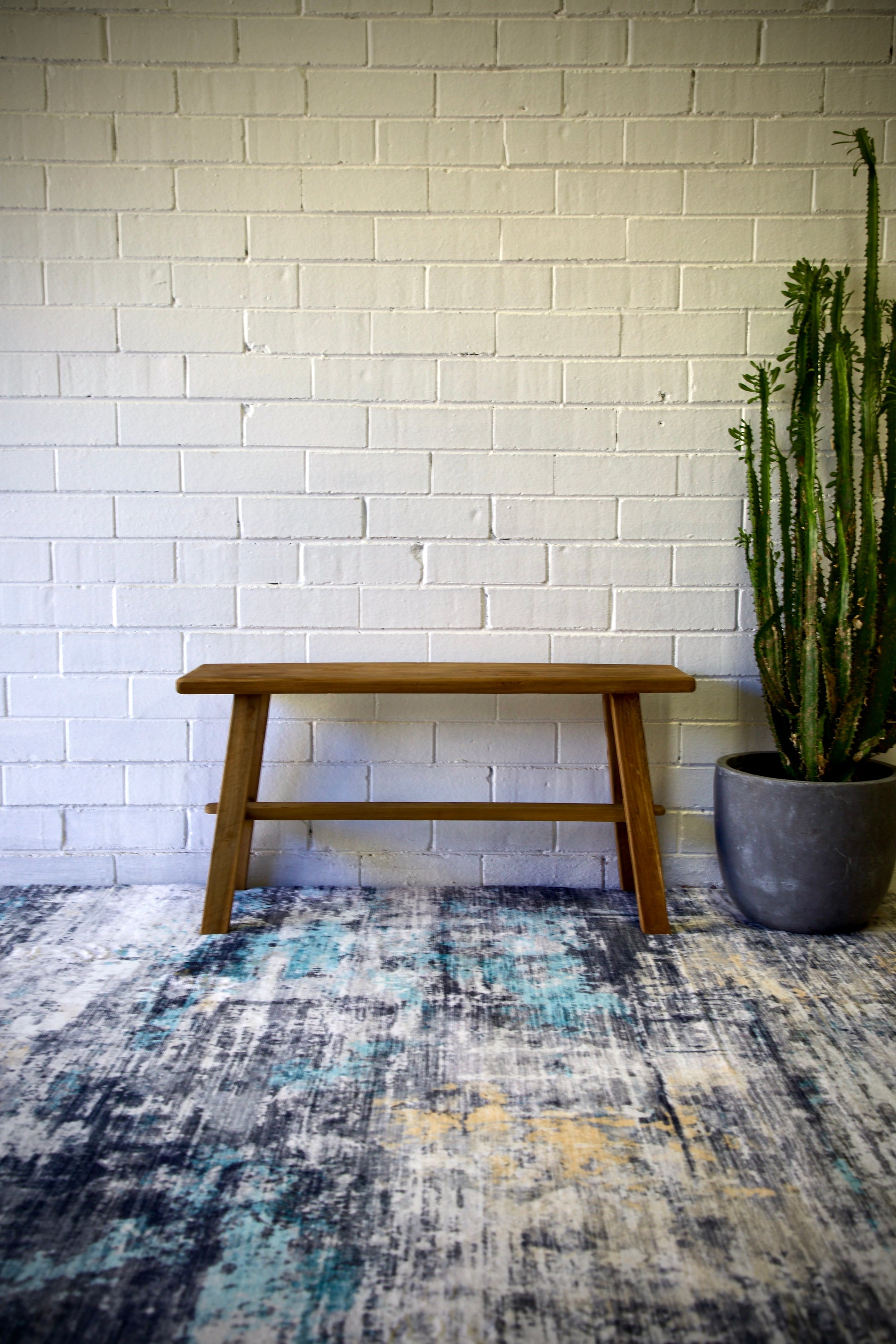 The Amchur 900 Bench is crafted from sustainable recycled teak. Features a solid plank top with A-Frame legs and centre support beam. Colour Natural Teak. Measures 900 Length x 250 Depth x 450 Height. Styled.