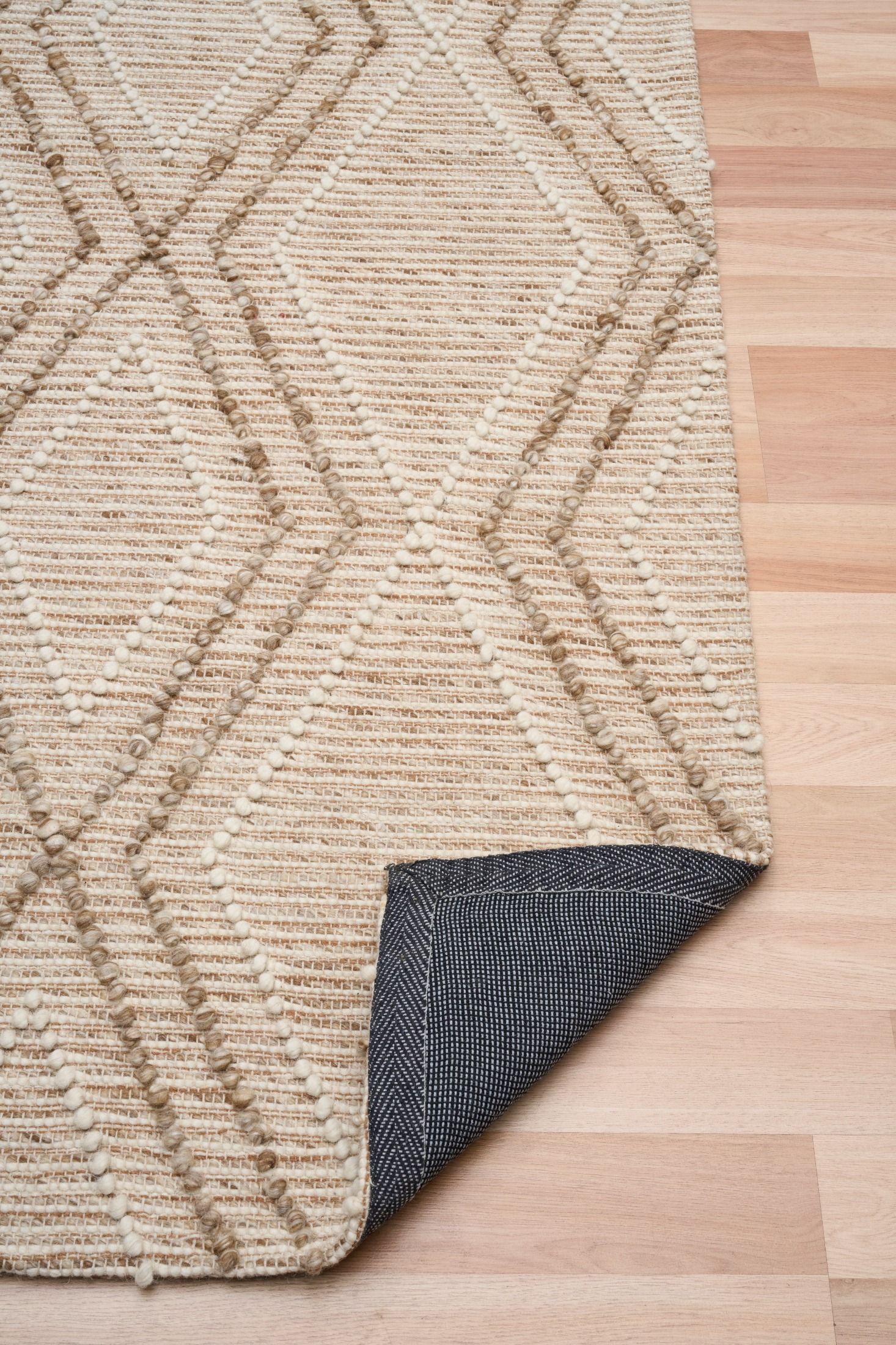 Anita Beige is a hand woven textured wool rug. Featuring a tribal geometric design with a 6-8mm pile height.  Colours Beige, Cream and Whites. Sizes 155 X 225, 200 X 290 and 300 X 400. Fold.