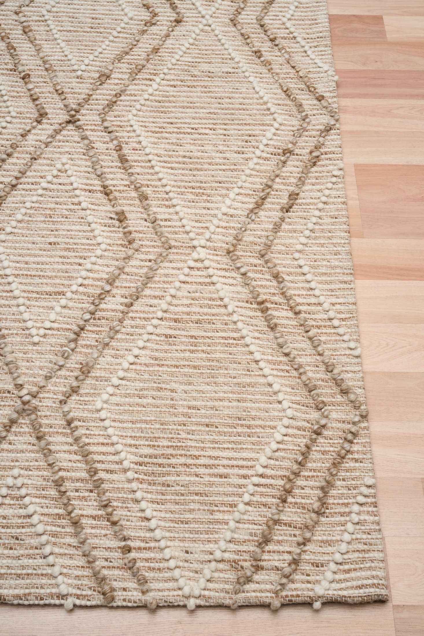 Anita Beige is a hand woven textured wool rug. Featuring a tribal geometric design with a 6-8mm pile height.  Colours Beige, Cream and Whites. Sizes 155 X 225, 200 X 290 and 300 X 400. Corner.