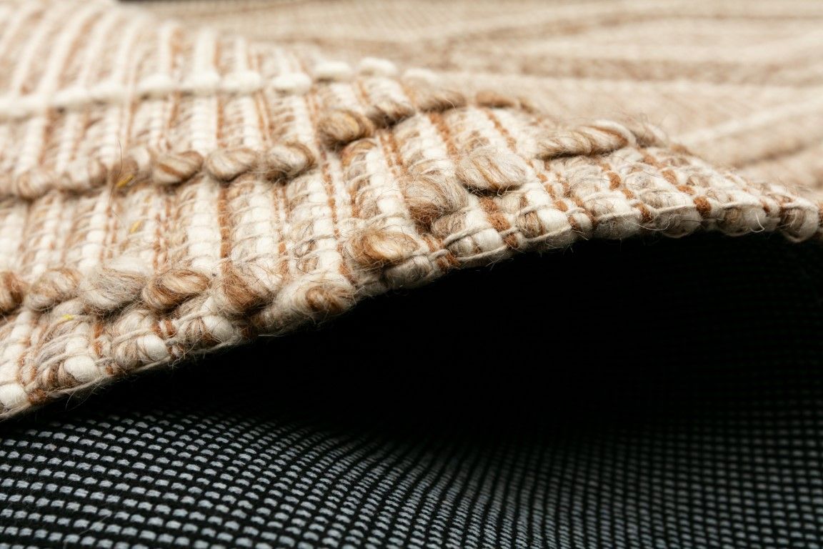 Anita Beige is a hand woven textured wool rug. Featuring a tribal geometric design with 6-8mm pile height.  Colours Beige, Cream and Whites. Sizes 155 X 225, 200 X 290 and 300 X 400. Side.