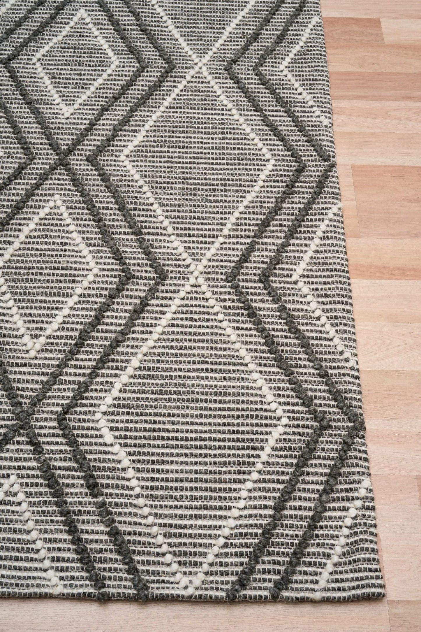 Anita Charcoal is a hand woven textured wool rug. Featuring a tribal geometric design with a 6-8mm pile height.  Colour Charcoal, Grey and White. Sizes 155 X 225, 200 X 290, 240 X 320 and 300 X 400. Corner.