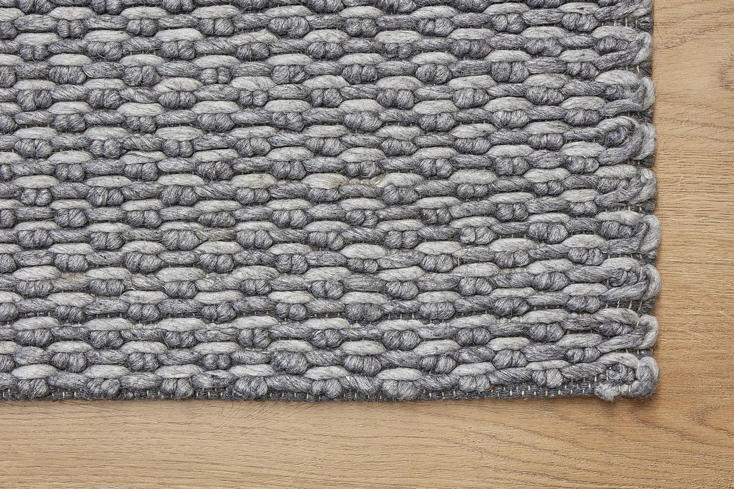 Ankara Stone is a Hand-woven, loop-textured rug crafted from a luxurious combination of wool and bamboo silk. Colours Grey and Light Grey. Sizes 160 X 230, 200 X 290, and 240 X 340. Corner.