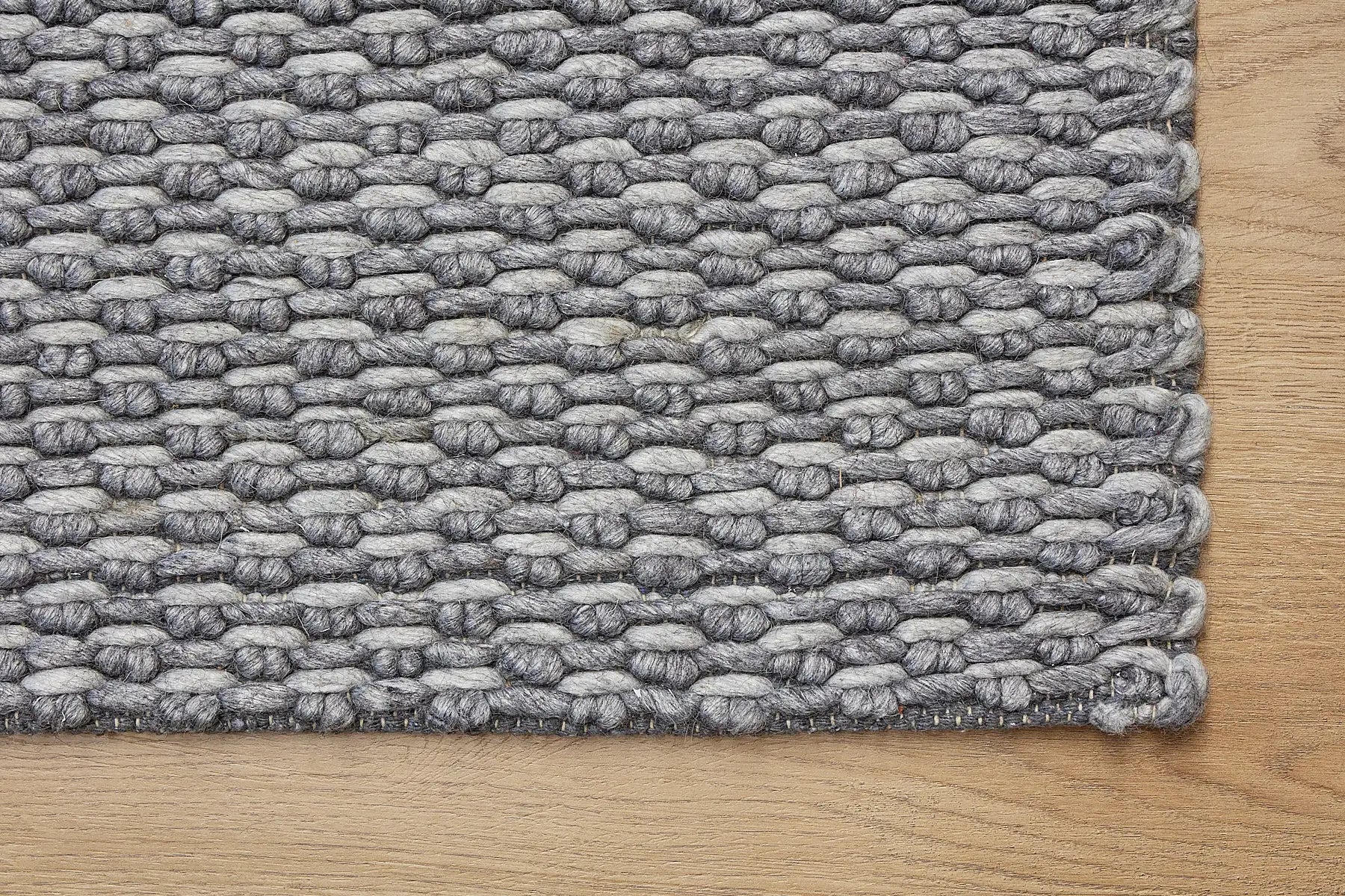 Ankara Stone is a Hand-woven, loop-textured rug crafted from a luxurious combination of wool and bamboo silk. Colours Grey and Light Grey. Sizes 160 X 230, 200 X 290, and 240 X 340. Corner.