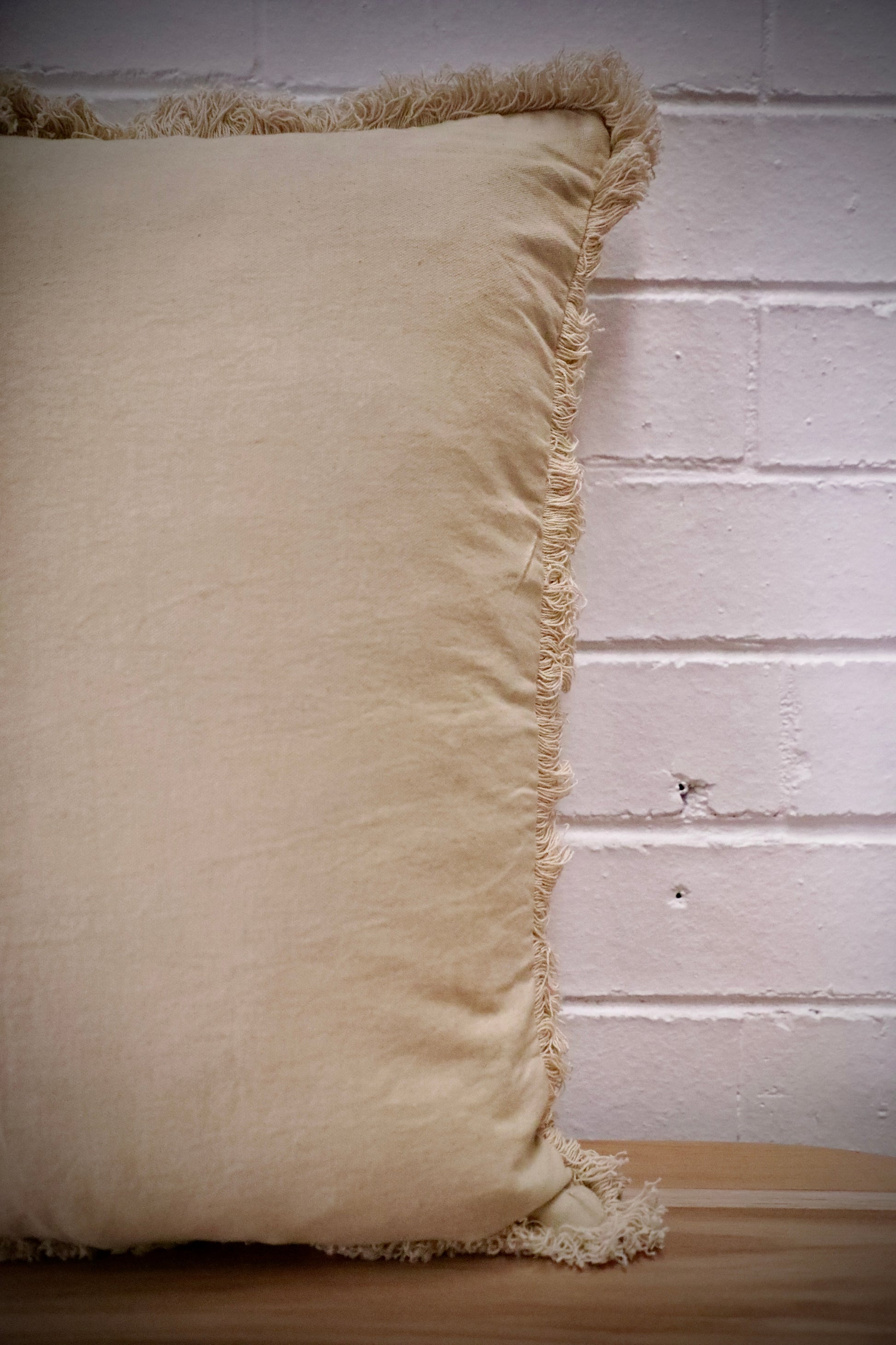 Our Antique Cream, cushion is hand crafted in India by skilled artisans. Features a soft feel, with small fringes around the edges. Colour Cream. Sizes 50 X 50 and 60 X 60. Side.
