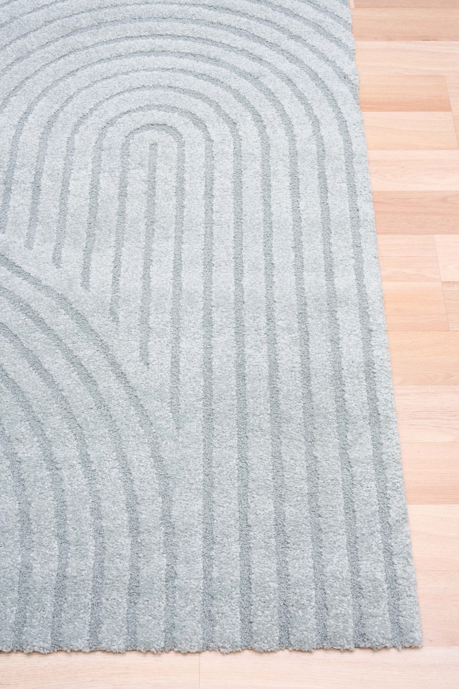 Arches - Light Blue, a modern rug design crafted with a unique blend of Heat Set Polypropylene and Polyester shrink yarn. Corner.