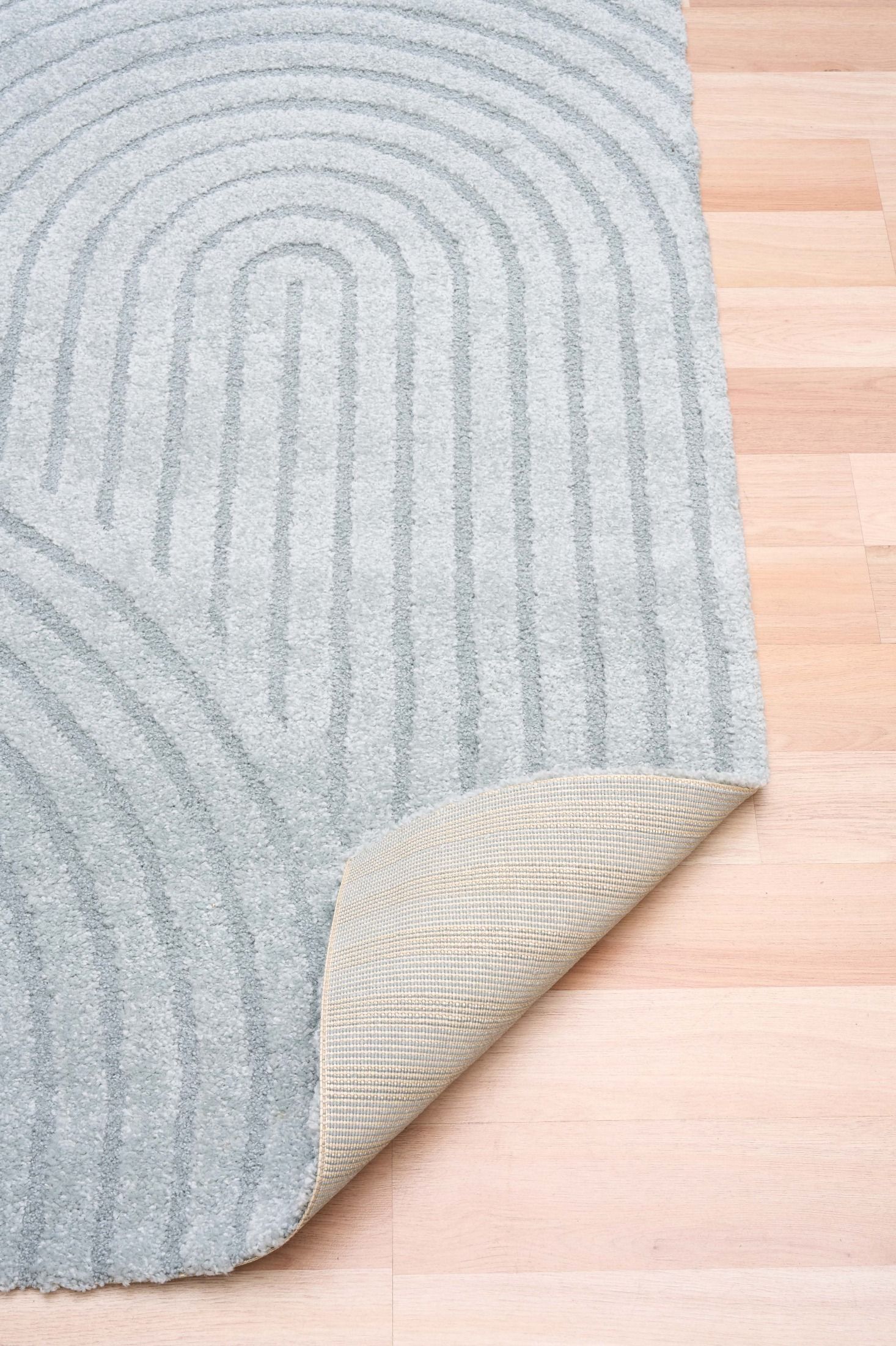 Arches - Light Blue, a modern rug design crafted with a unique blend of Heat Set Polypropylene and Polyester shrink yarn.  Fold.