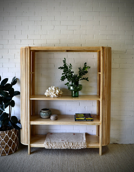 The Aries - Tall bookshelf is a coastal/contemporary designed piece. It features curved slated sides and and 3 shelves. Made from sustainable bleached fruitwood. Colour Natural. Measuring 1500 length X 330 depth X 1700 height. Styled.