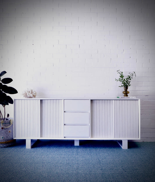 The Ashland 2 Sliding Door 3 Drawer - White Buffet - a Coastal Contemporary Teak Buffet. Featuring 2 sliding doors, and 3 drawers, supported by wooden runners. Measures 1800 Length X 400 Depth X 900 Height. Styled.