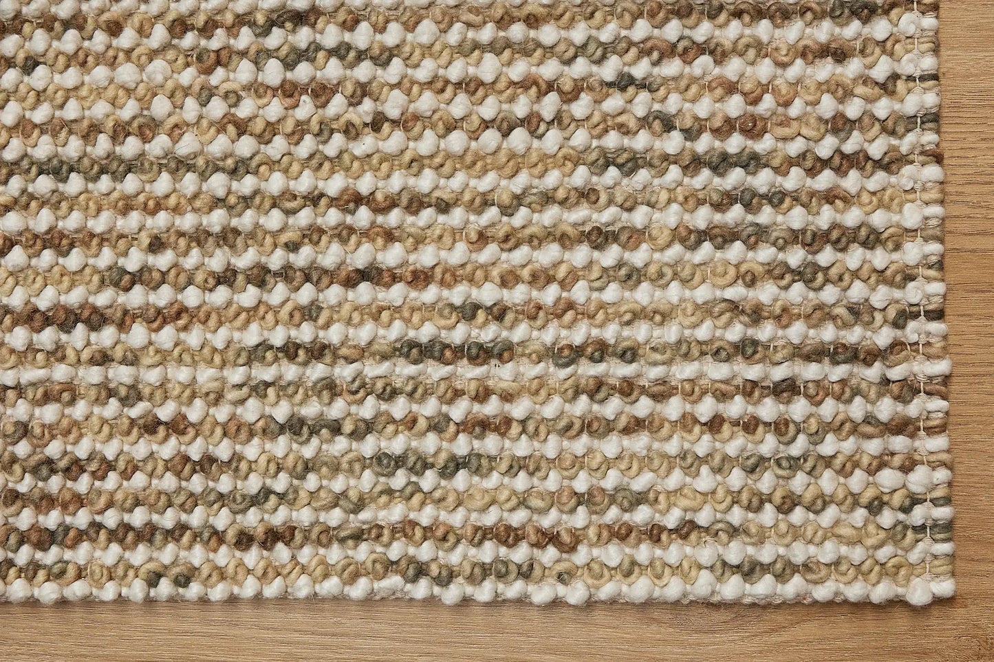 Avila - Beige is a handwoven loop piled carpet. It features a blend of fine wool and viscose, with a pile height of 16-18mm. Colours Beige with Brown accents. Sizes 160 X 230, 200 X 290 and 240 X 340. Corner.