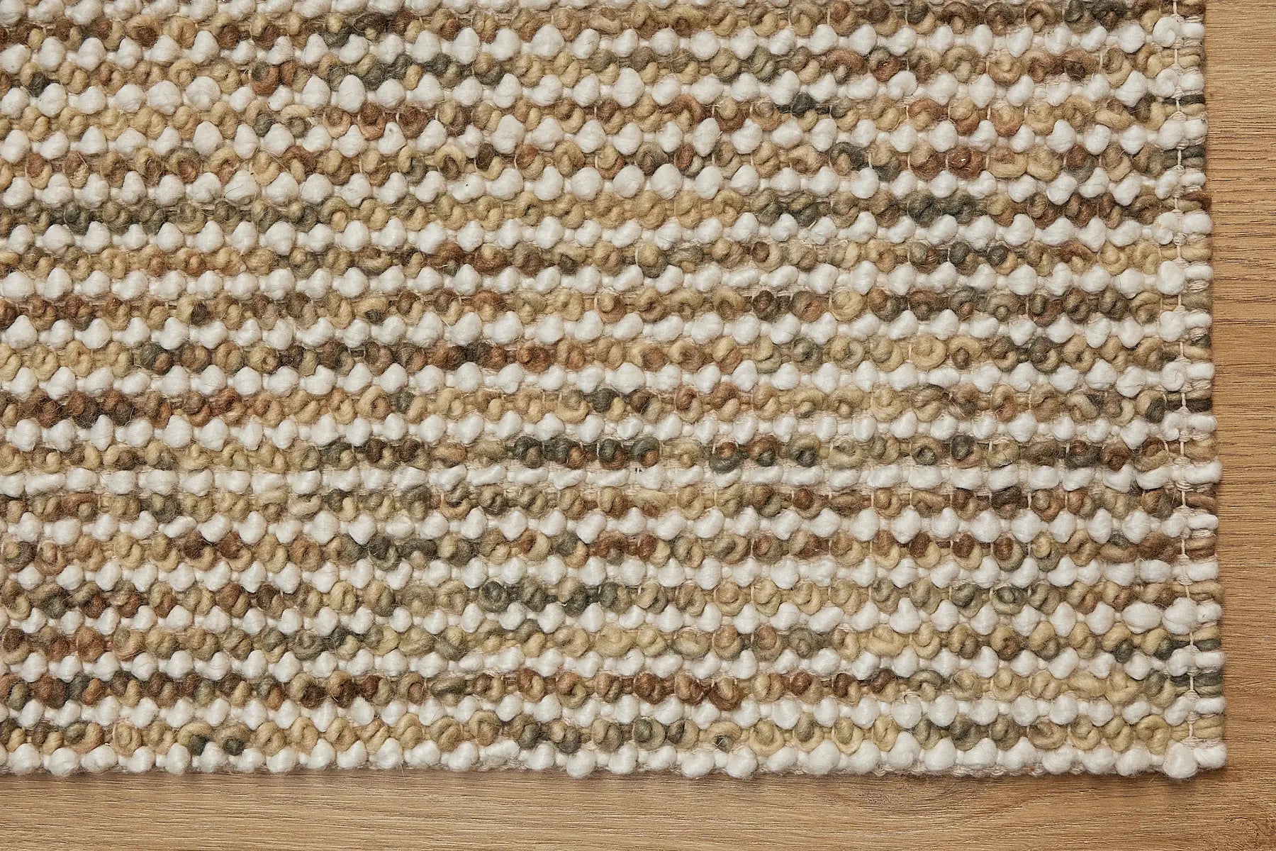 Avila - Beige is a handwoven loop piled carpet. It features a blend of fine wool and viscose, with a pile height of 16-18mm. Colours Beige with Brown accents. Sizes 160 X 230, 200 X 290 and 240 X 340. Corner.