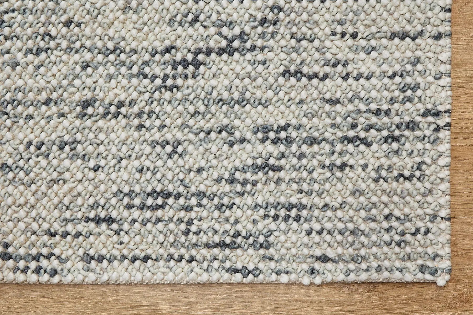 Avila - Forrest is a handwoven loop piled carpet. It features a blend of fine wool and viscose, with a pile height of 16-18mm. Colours White with Forrest Green accents. Sizes 160 X 230, 200 X 290 and 240 X 340. Corner.