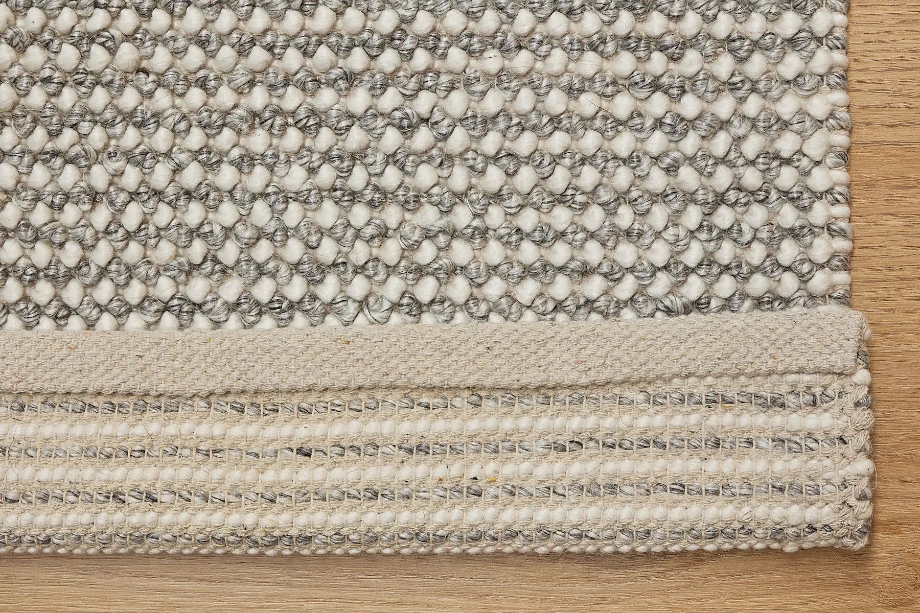Avila - Grey is a handwoven loop piled carpet. It features a blend of fine wool and viscose, with a pile height of 16-18mm. Colours Light Grey with Dark Grey accents. Sizes 160 X 230, 200 X 290 and 240 X 340. Fold