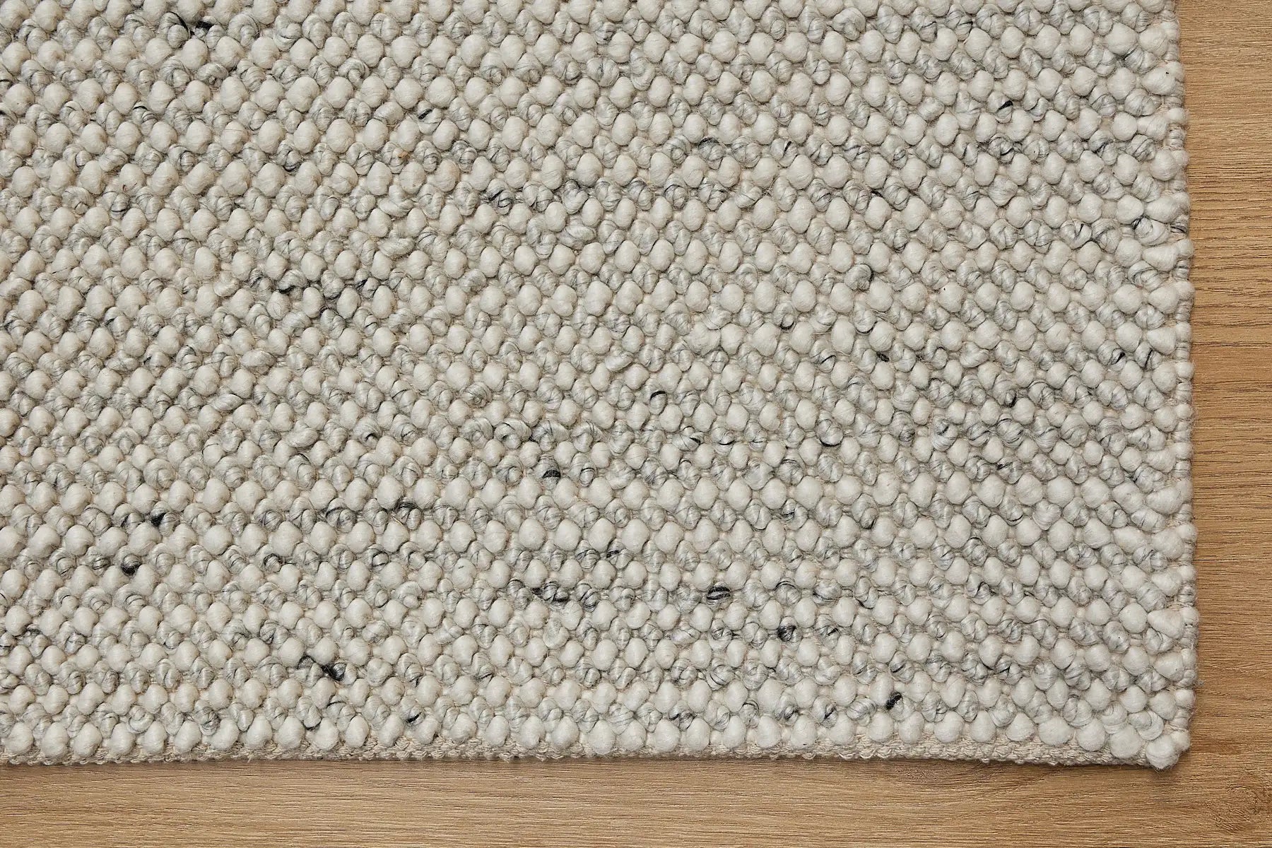 Avila - Natural is a handwoven loop piled carpet. It features a blend of fine wool and viscose, with a pile height of 16-18mm. Colours Cream with Brown and Beige accents. Sizes 160 X 230, 200 X 290 and 240 X 340. Corner.