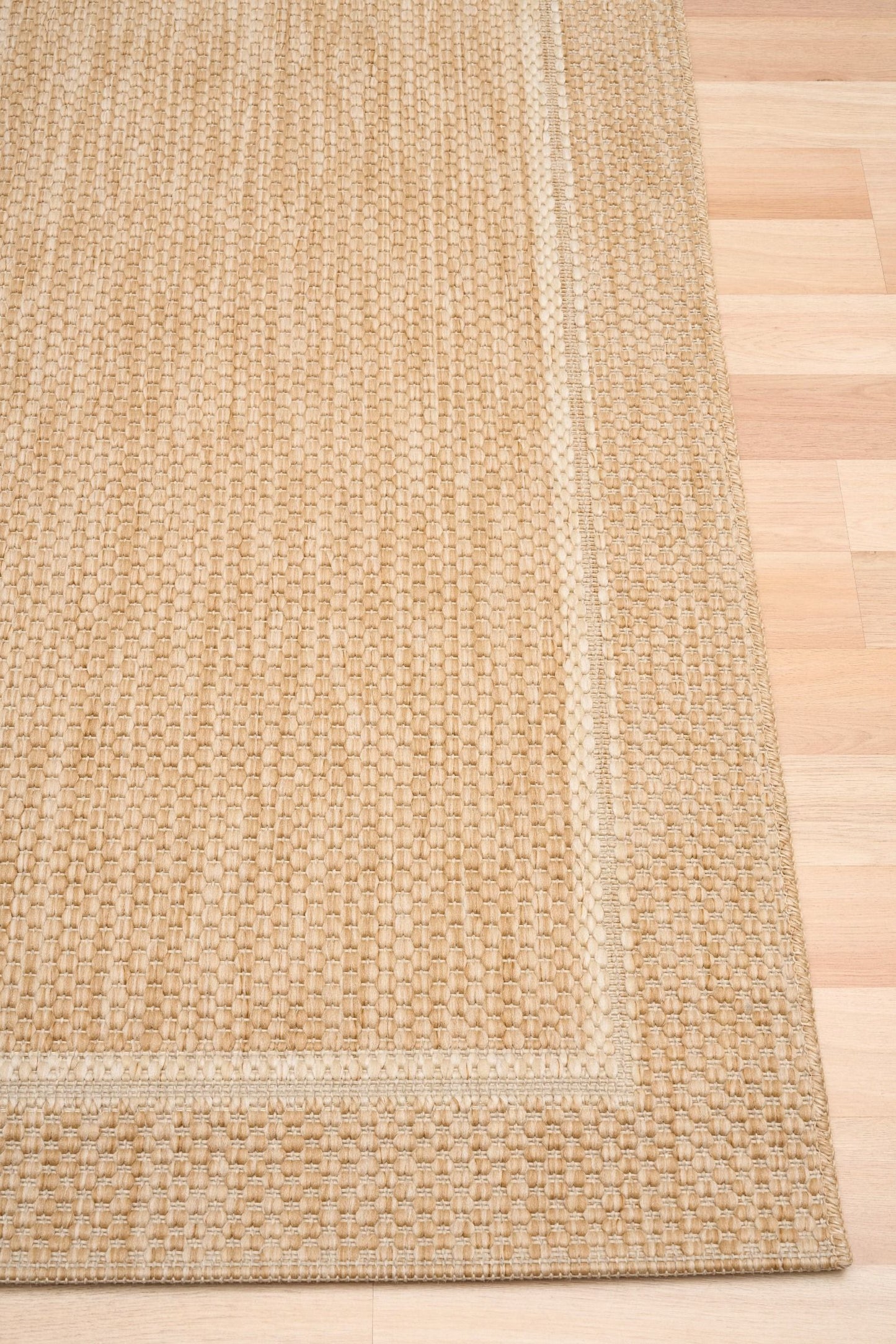 Barton Beige 41505 indoor/outdoor rug featuring soft beige tones and a subtle textured pattern, power-loomed from UV-stabilised polypropylene for lasting durability. Colour Beige. 3 sizes. Corner.
