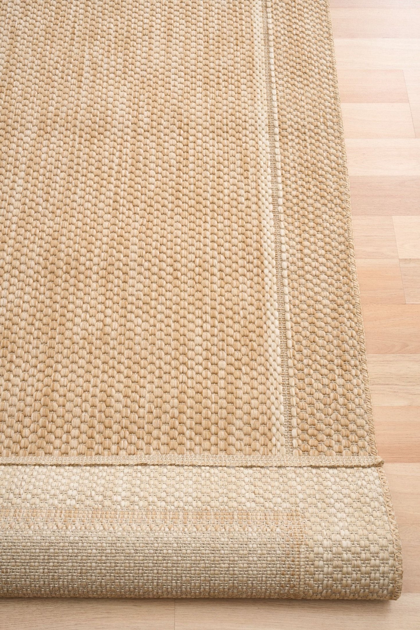 Barton Border Beige indoor/outdoor rug featuring soft beige tones and a subtle textured pattern, power-loomed from UV-stabilised polypropylene for lasting durability. Colour Beige. 3 sizes. Fold.