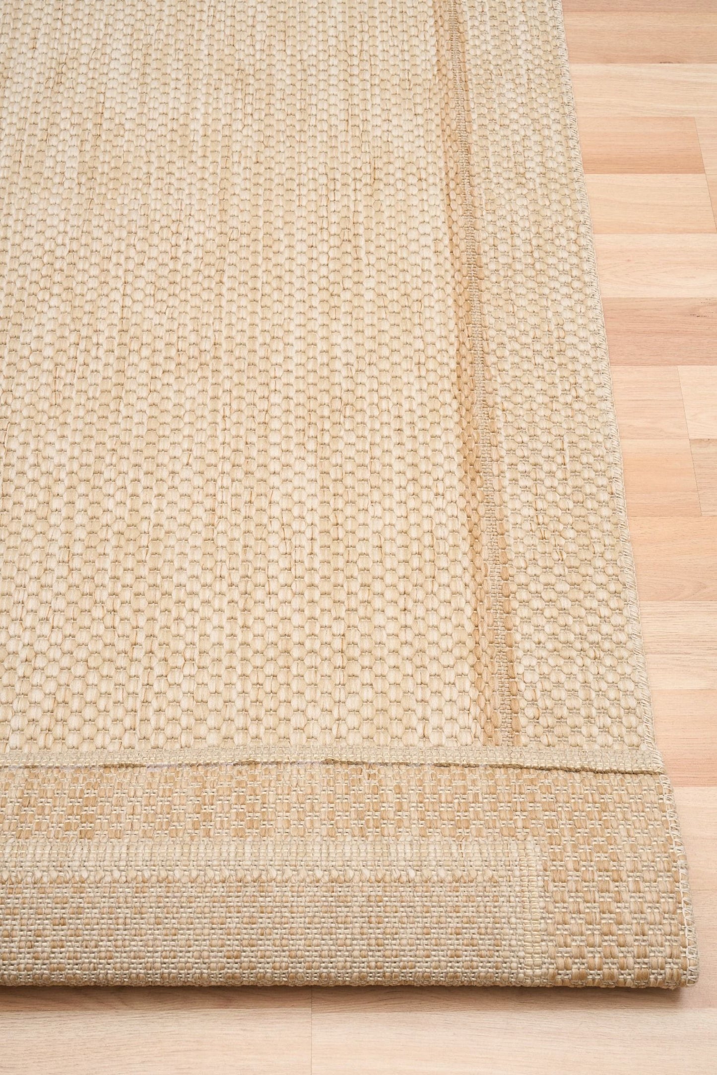 Barton Border Cream indoor/outdoor rug featuring soft cream tones and a subtle textured pattern, power-loomed from UV-stabilised polypropylene for lasting durability. Colour Cream. 3 sizes. Fold.