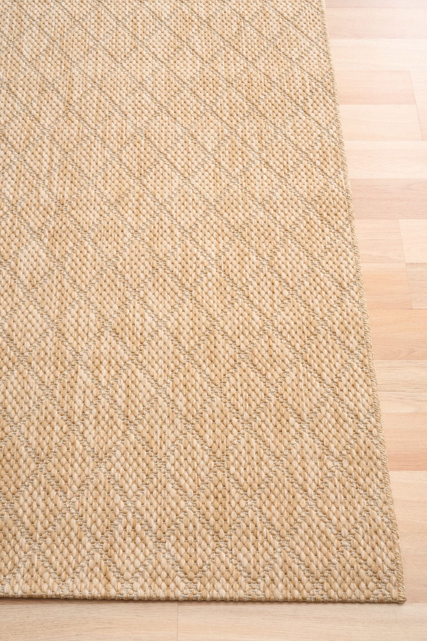 Barton Diamond Beige indoor/outdoor rug featuring soft beige tones and a subtle textured pattern, power-loomed from UV-stabilised polypropylene for lasting durability. Colour Beige. 3 sizes. Corner.
