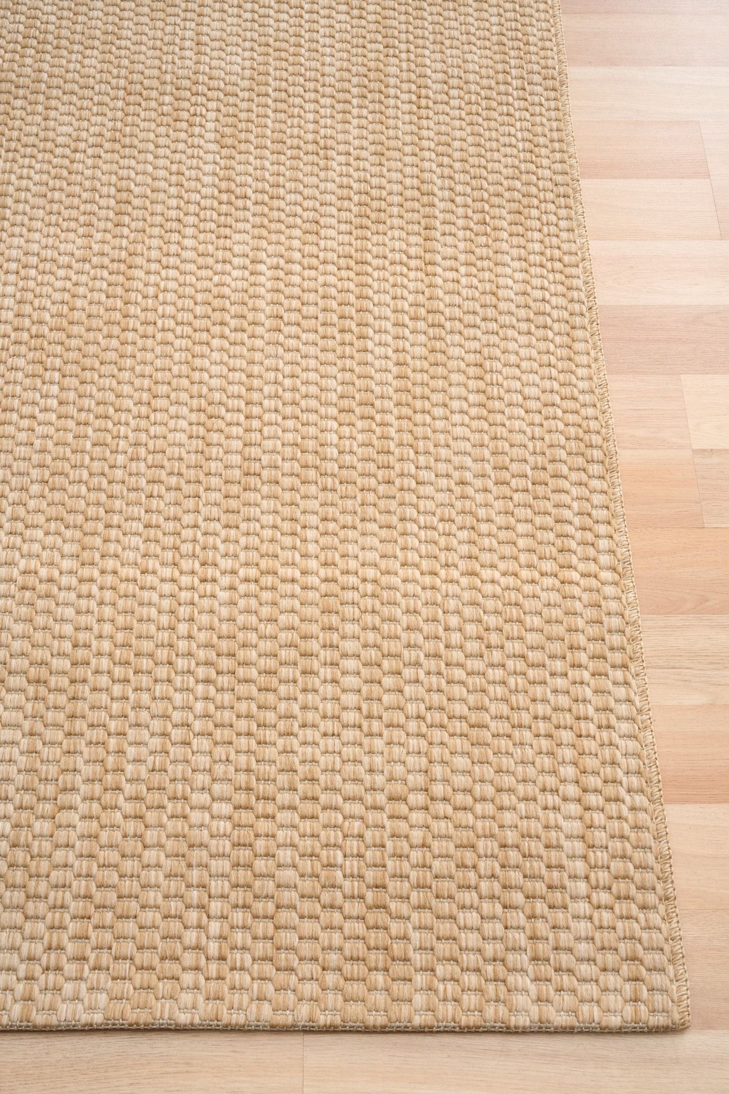 Barton Twill Beige indoor/outdoor rug featuring soft beige tones and a subtle textured pattern, power-loomed from UV-stabilised polypropylene for lasting durability. Colour beige. 3 sizes. Corner.
