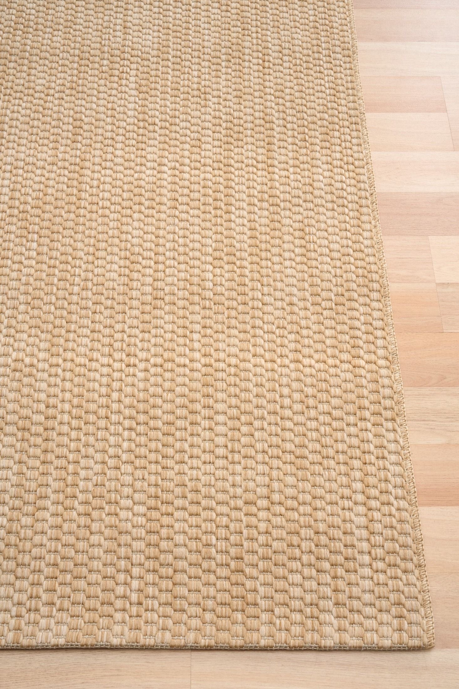 Barton Twill Beige indoor/outdoor rug featuring soft beige tones and a subtle textured pattern, power-loomed from UV-stabilised polypropylene for lasting durability. Colour beige. 3 sizes. Corner.