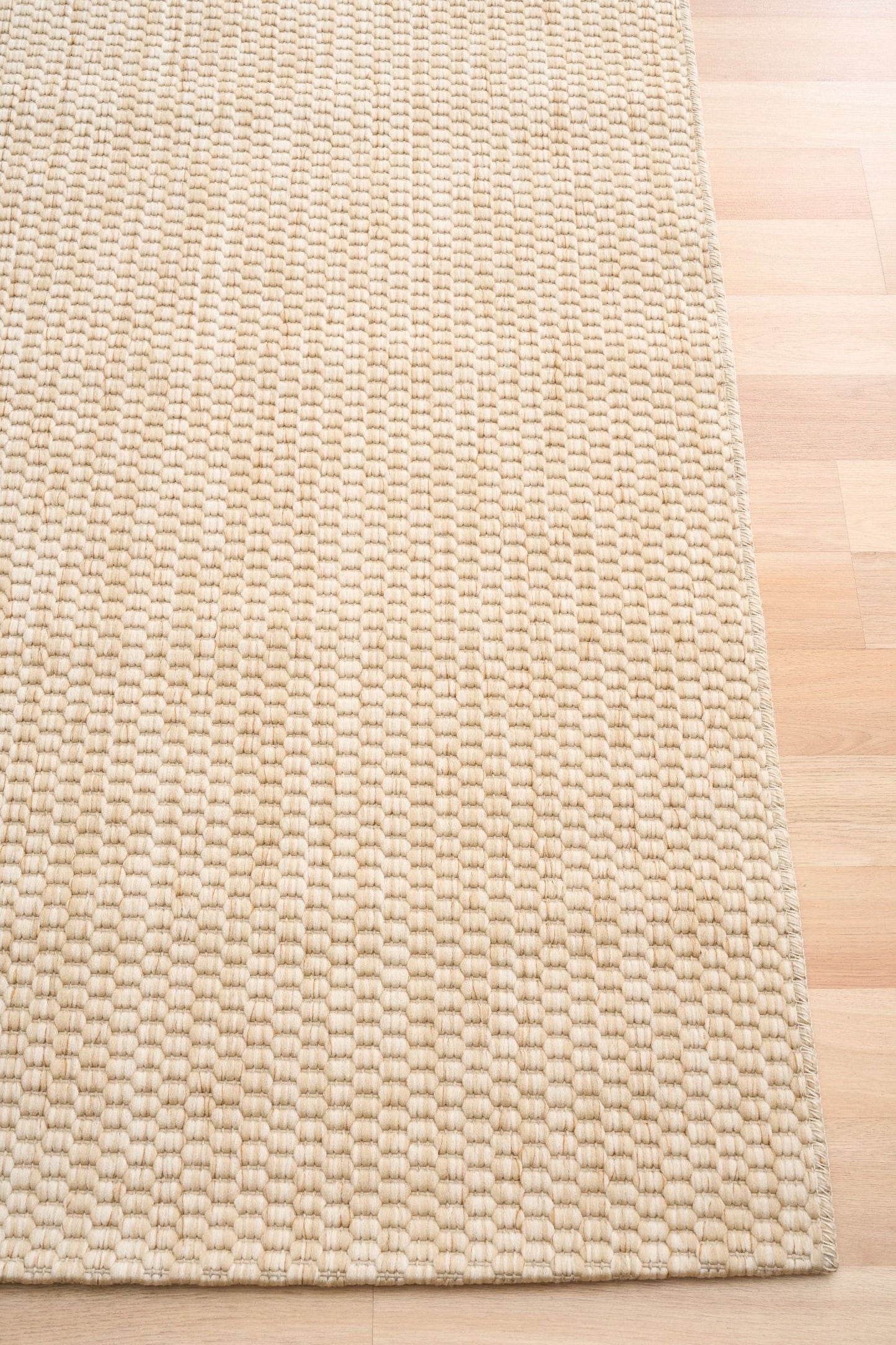 Barton Twill Cream indoor/outdoor rug featuring soft cream tones and a subtle textured pattern, power-loomed from UV-stabilised polypropylene for lasting durability. Colour cream. 3 sizes. Corner.