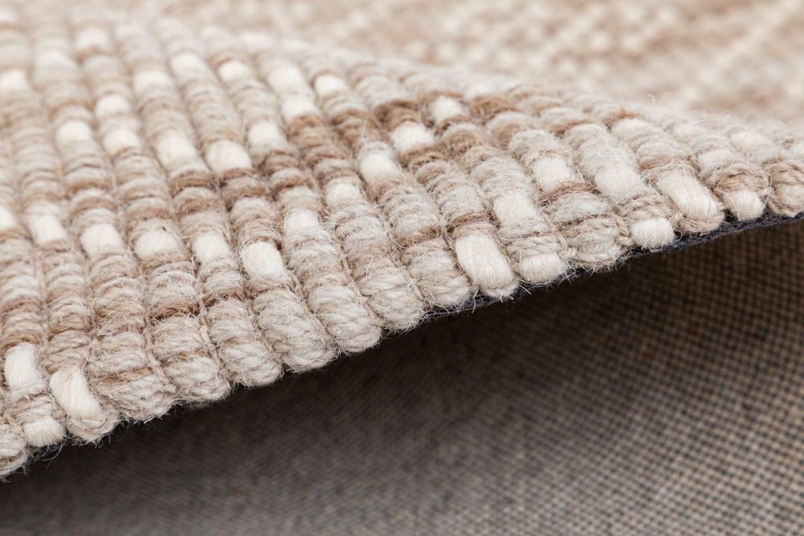 Bellevue Natural is a textured hand woven  wool and viscose rug.  Featuring a tribal diamond aztec design. Colours Beige/Cream with White Patterns. Size 300 X 400. Side.