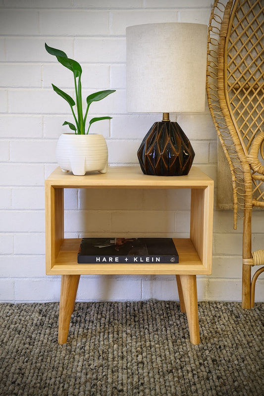 The Bimberi Bedside is a modern open shelf nightstand. It is crafted from sustainable organic white cedar. Colour Natural. Measures 520 length X 400 depth X 560 height. Front Styled.
