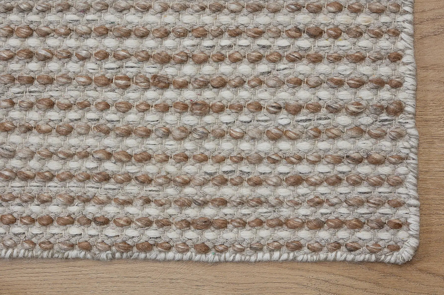 Boa - Natural is a hand-woven flatweave, made of wool with a pile height of 7-9mm. Colours Cream with Beige accents. Sizes 160 X 230, 200 X 290, and 240 X 340. Corner.