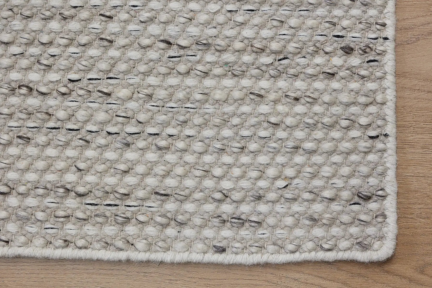 Boa - Salt & Pepper is a hand-woven flatweave, made of wool with a pile height of 7-9mm. Colours White with Black and Grey  accents. Sizes 160 X 230, 200 X 290, and 240 X 340. Corner.