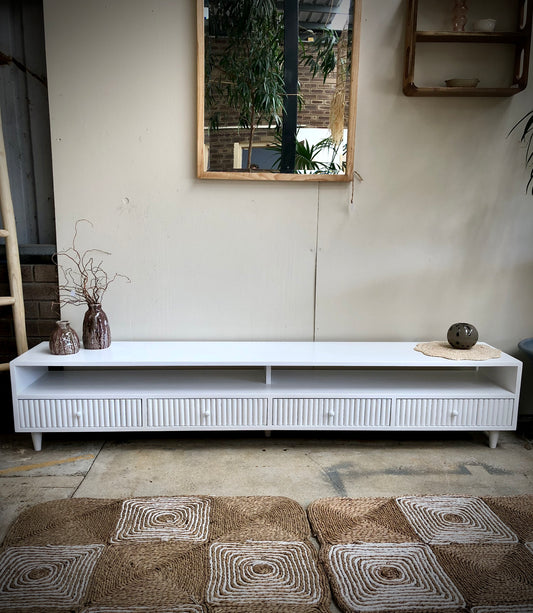 The Brando 4 Drawer White Entertainment Unit is a modern/contemporary designed piece. It has 4 textured drawers and 2 open shelves. Crafted from sustainable white cedar. Colour white. Measures 2100 length X 400 depth X 400 height. Styled.