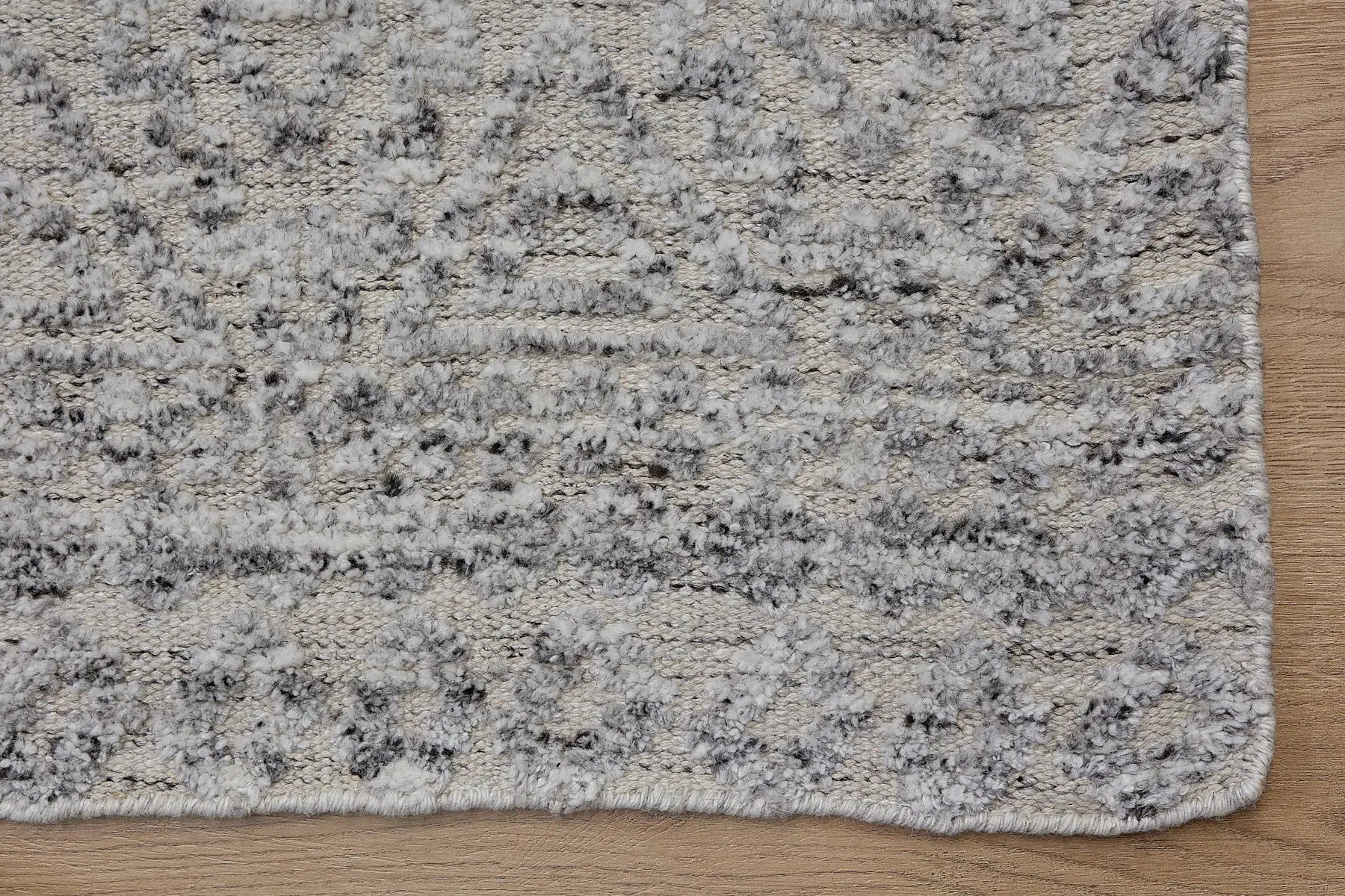 Brazil - Frost is a Boho Tribal Hand-Knotted Wool and Bamboo Silk Rug with a pile height of 7-9mm. Colours White with Light Grey and Dark Grey accents. Sizes 160 X 230, 200 X 290, and 240 X 340. Corner.