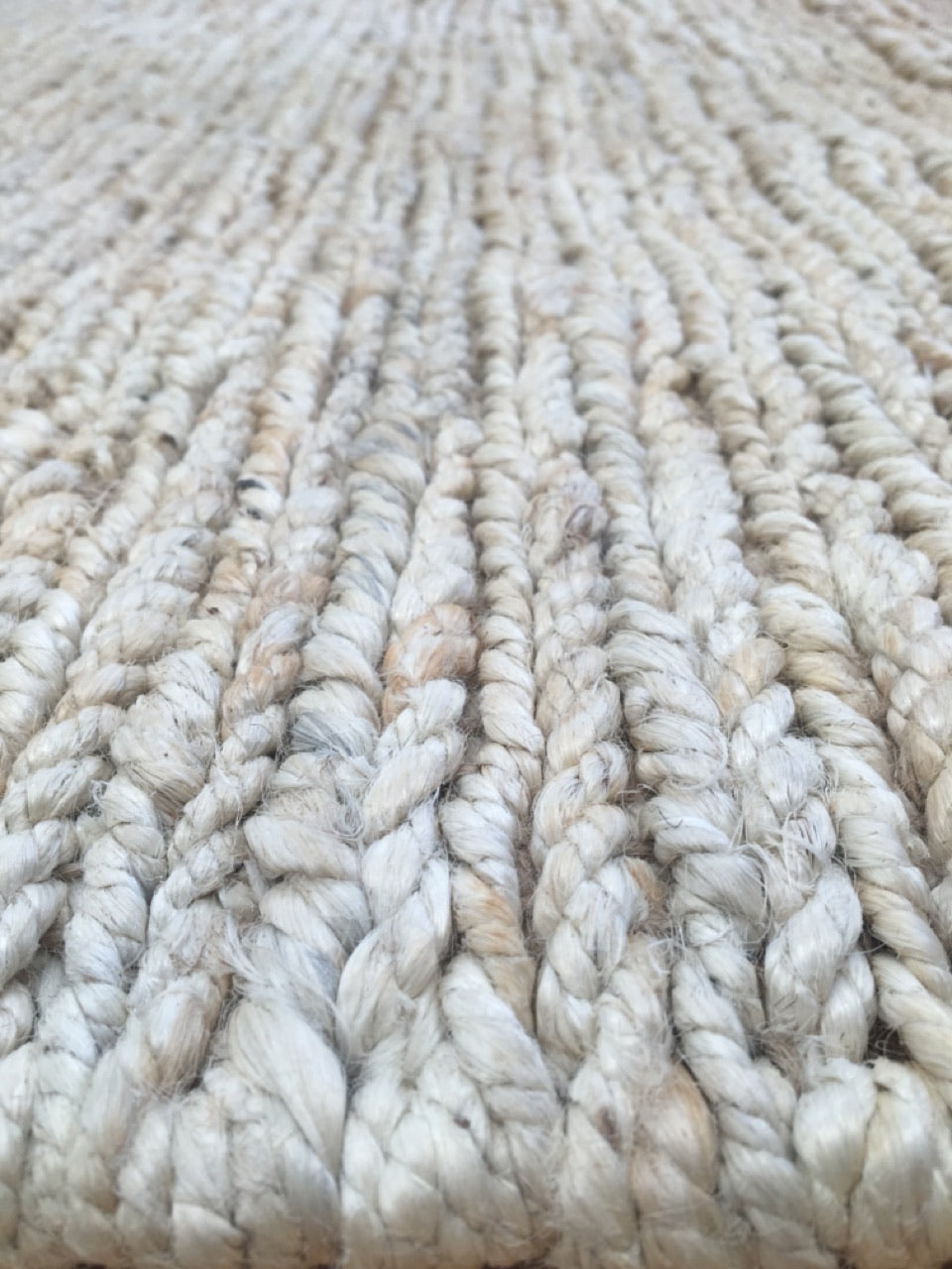 Byron Bleach hand-woven hemp rug in a braided-style flatweave. Bleached white. Sizes 155 x 225, 200 x 290 and 240 x 320 cm. Angle close view.