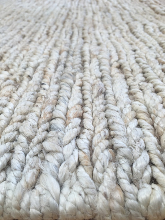Byron Bleach hand-woven hemp rug in a braided-style flatweave. Bleached white. Sizes 155 x 225, 200 x 290 and 240 x 320 cm. Angle close view.