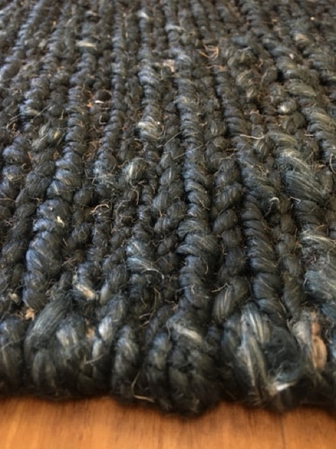 Byron Black hand-woven hemp rug in a braided-style flatweave. Black. Sizes 200 x 290 and 240 x 320 cm. Angle close view.